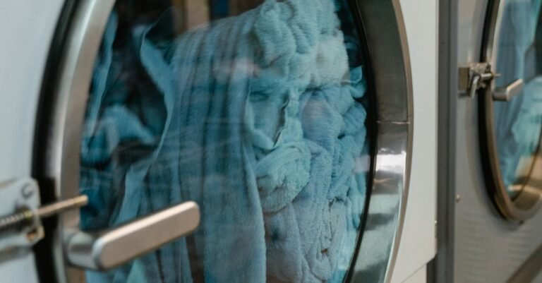 Close-up of an industrial laundry machine with blue towels inside, highlighting automated service.
